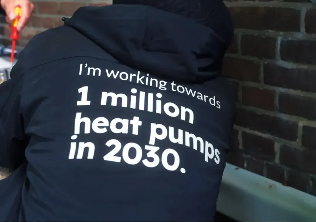 Quatt-teamlid met de tekst 'I'm working towards 1 million heat pumps in 2030' op zijn jas